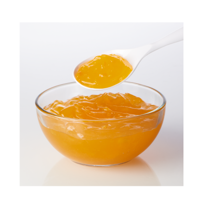 Bowl of golden peach filling with a spoonful being lifted, showcasing its smooth and fruity texture.