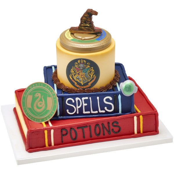 A magical tiered cake shaped like spell books, topped with the Sorting Hat and a Slytherin House coaster.