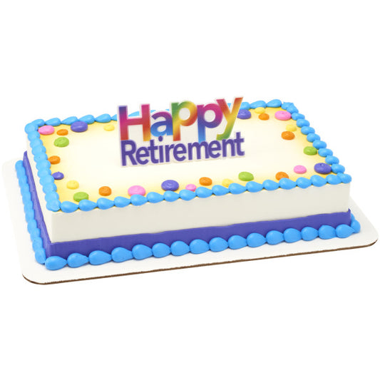 Rectangular cake decorated with blue and rainbow accents, featuring the "Happy Retirement" rainbow topper at the center