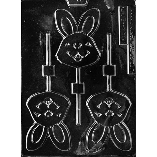 Clear plastic chocolate lollipop mold with three bunny face cavities featuring tall upright ears, inner-ear outlines, a rounded nose, and a smiling mouth with a small tooth, plus stick channels.