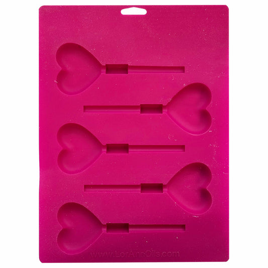 Back view of the same heart-shaped lollipop mold showing cavity depth and stick placement in a pink silicone sheet.