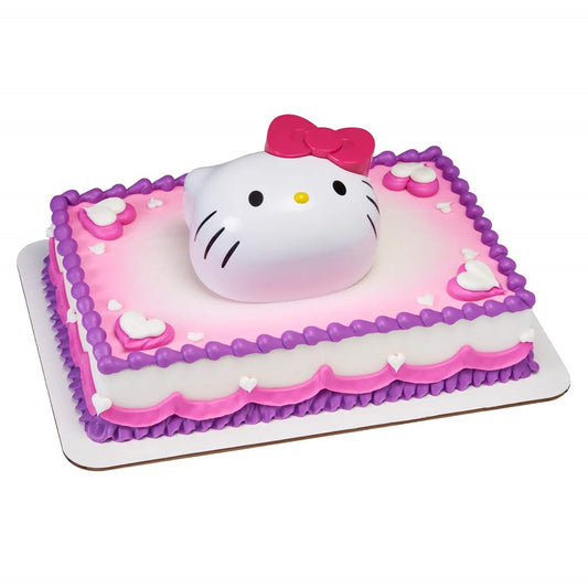 A square cake topped with a large Hello Kitty figure and surrounded by delicate icing hearts and bows, including a surprise toy set, creating a delightful centerpiece for Hello kitty fans.