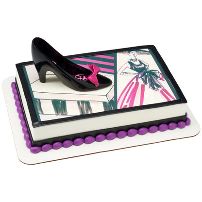 Fashion-themed sheet cake with illustration-style decorations, topped with the black high heel and magenta bow.