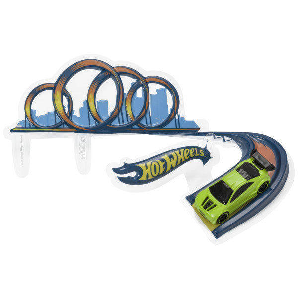 A green Hot Wheels drift car and a 3D race track plaque featuring triple loop designs against a city skyline.