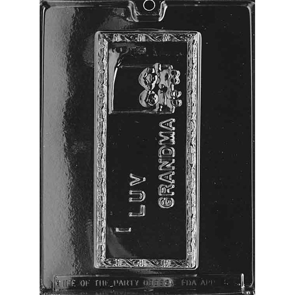 Clear plastic chocolate mold with one long rectangular cavity that says “I Luv Grandma” and includes a small flower pot design.