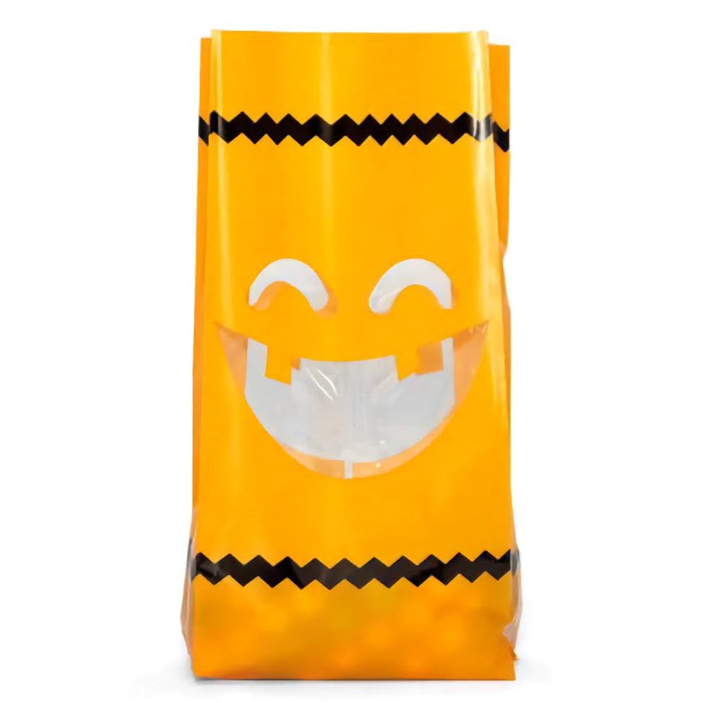 A Halloween themed jack-o-lantern cello treat bag. The bag is orange with transparent eyes and mouth as well as a black zip-zag border