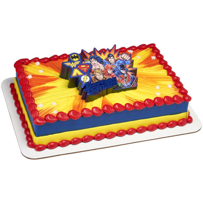 A rectangular cake with a bright yellow and red superhero burst design, featuring the light-up Justice League™ topper at the center.