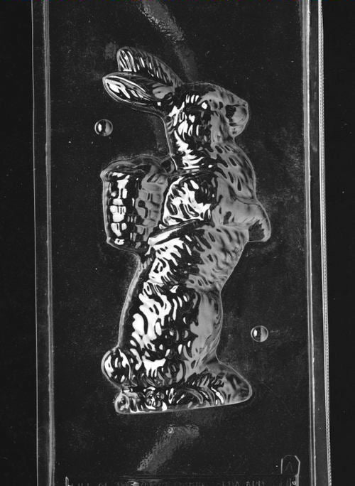 Clear plastic chocolate mold showing the front half of a tall bunny with textured fur and an attached woven basket on its back, designed for a 3D chocolate figure.