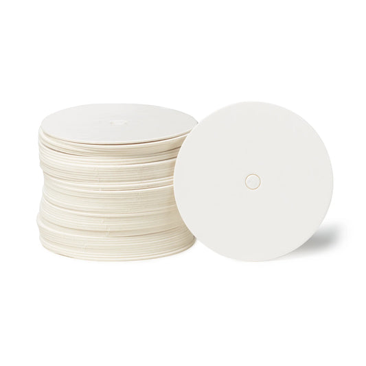 Stack of round white cake pop boards with straight edges and glossy finish, each with a center hole, shown with one board propped forward.