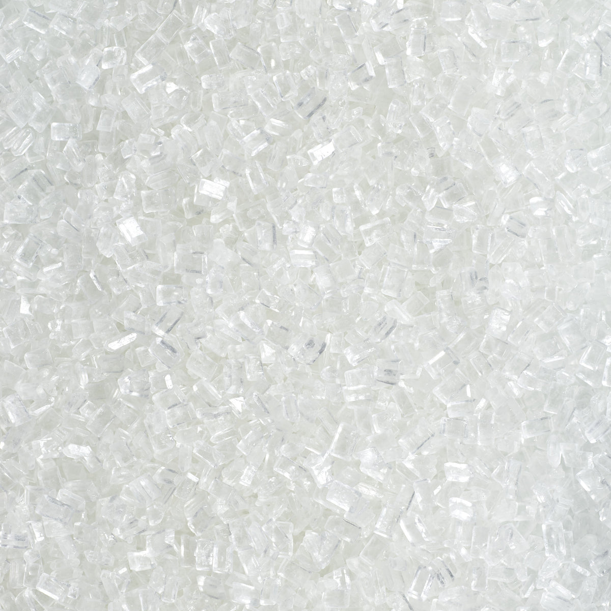Close-up of DecoPac Clear Large Crystal Sugar showing chunky, translucent white sugar crystals with irregular rectangular shapes and sparkling, glass-like surfaces.