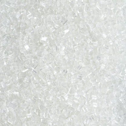 Close-up of DecoPac Clear Large Crystal Sugar showing chunky, translucent white sugar crystals with irregular rectangular shapes and sparkling, glass-like surfaces.