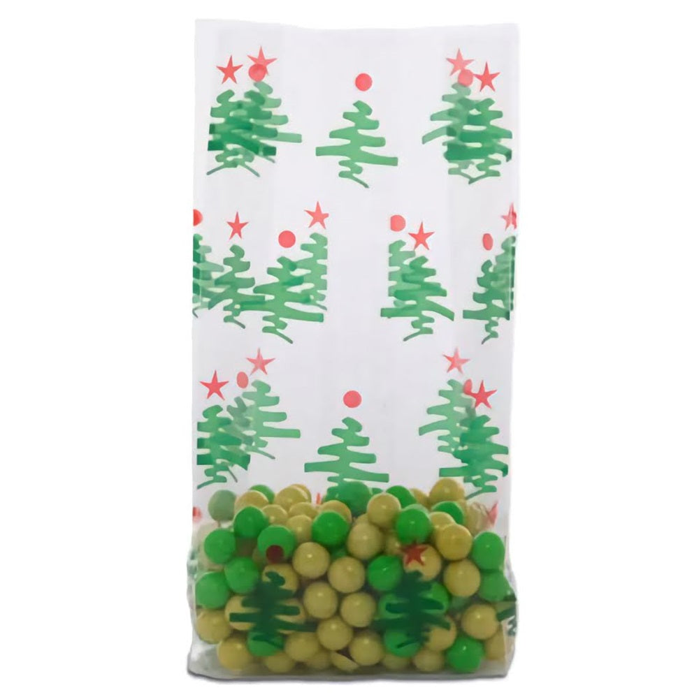 A large cellophane treat bag filled partway with green and yellow round candies, with the top section of the bag showcasing a repeating pattern of green Christmas trees and red stars on a white background. The trees and stars are distributed evenly across the bag, creating a festive and colorful holiday design.