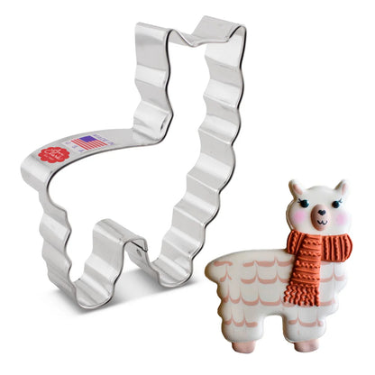 Llama cookie cutter displayed alongside a decorated cookie featuring a white llama with a cozy orange scarf, rosy cheeks, and a cute smile.