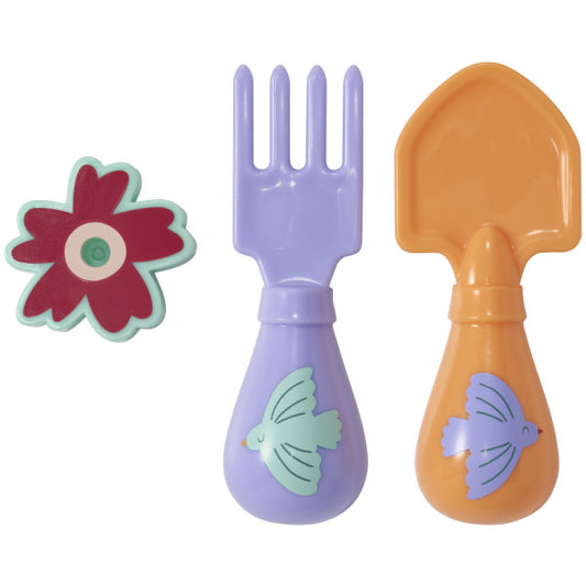 A pastel-colored toy fork and shovel with bird designs and a red flower candle holder, designed as a cake decoration.