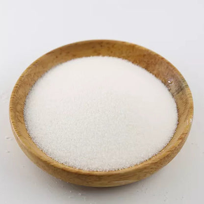 Small round wooden bowl filled with fine white powder on a white background, shown as encapsulated malic acid ingredient for sour candy making.