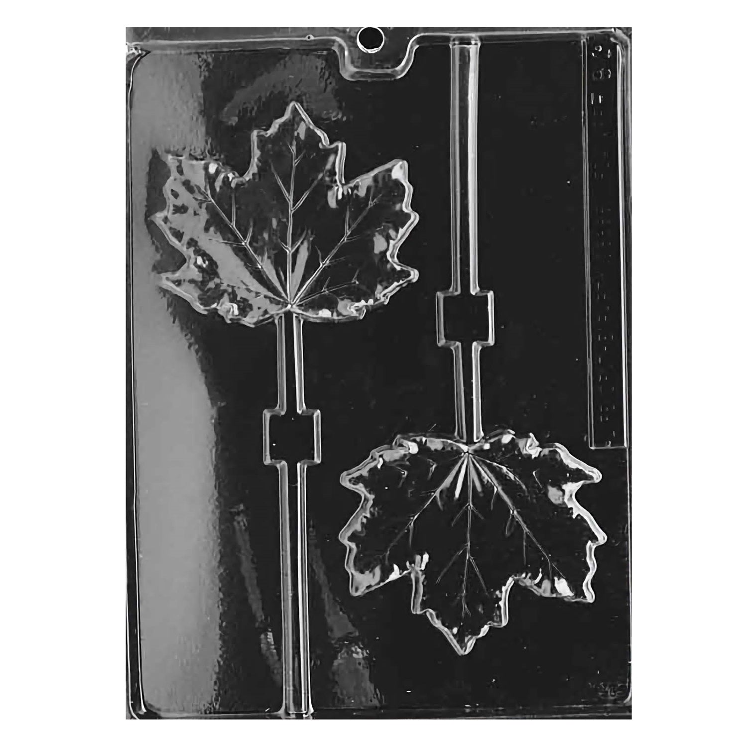 The image displays a clear plastic chocolate mold designed for creating maple leaf-shaped suckers. The mold features two large cavities, each intricately detailed to replicate the iconic, lobed leaves of a maple tree, complete with textured veins for added realism. Each leaf cavity is equipped with a slot for inserting a sucker stick.
