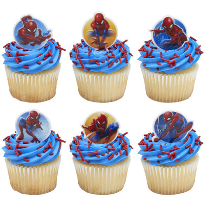 Six vanilla cupcakes with bright blue frosting swirls and red sprinkle jimmies, each topped with a different Spider-Man cupcake ring.