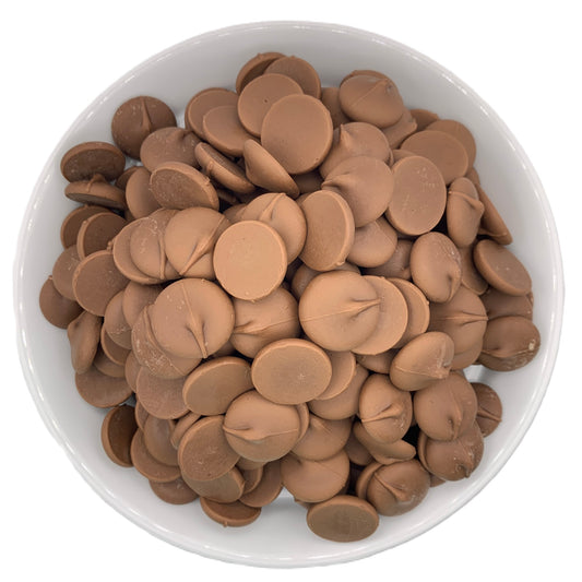 A top-down view of a bowl filled with Merckens Marquis real milk chocolate melting wafers. The image captures the circular shape and smooth surface of the wafers, highlighting their consistent size and chocolatey sheen. The white bowl accentuates the deep brown color of the milk chocolate wafers, providing a clear view of their arrangement and texture.