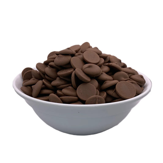 A bowl filled with Merckens Marquis real milk chocolate melting wafers. The wafers are round, flat, and brown, arranged neatly in the bowl, showcasing their smooth texture and uniform size. The bowl is white and contrasts with the rich brown color of the chocolate wafers.