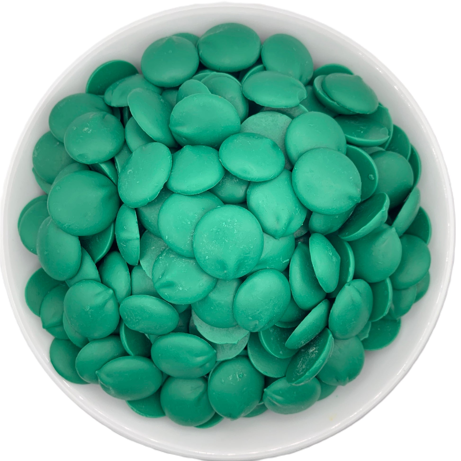 Top view of a white bowl full of Merckens dark green chocolate melting wafers, showcasing the vibrant green color perfect for themed desserts and festive treats.