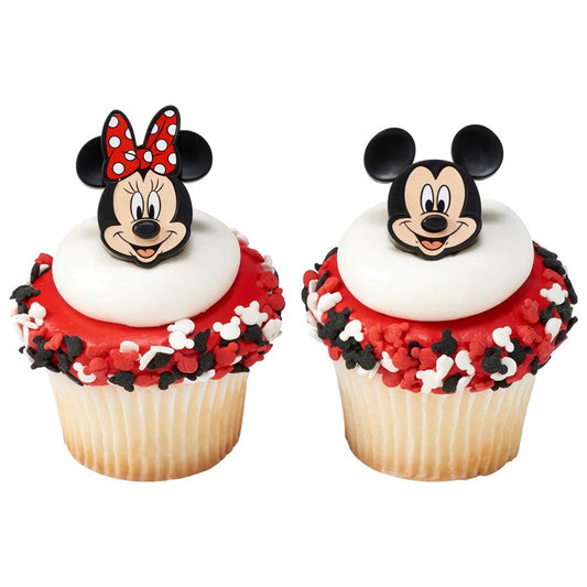 Delightful cupcake toppers featuring the iconic Mickey and Minnie Mouse faces, adorned with red and white icing topped with matching mouse ear silhouettes, perfect for themed parties and available at Lynn's Cake, Candy, and Chocolate Supplies.
