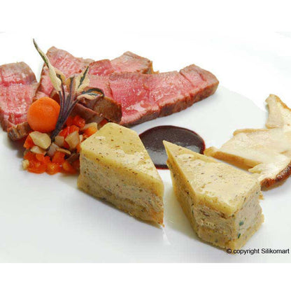 Gourmet plated dish featuring savory molded portions from a rectangular silicone mold, served with sliced beef and vegetables.