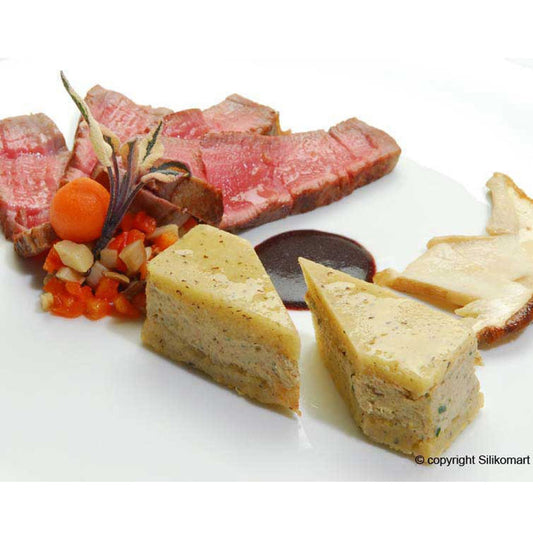 Gourmet plated dish featuring savory molded portions from a rectangular silicone mold, served with sliced beef and vegetables.