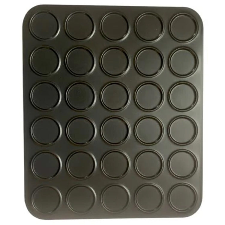 Mini macaron baking pan with 30 round, shallow cavities arranged in a grid on a dark non-stick sheet, shown from above on a white background.