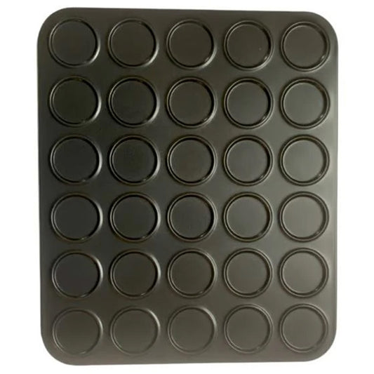 Mini macaron baking pan with 30 round, shallow cavities arranged in a grid on a dark non-stick sheet, shown from above on a white background.