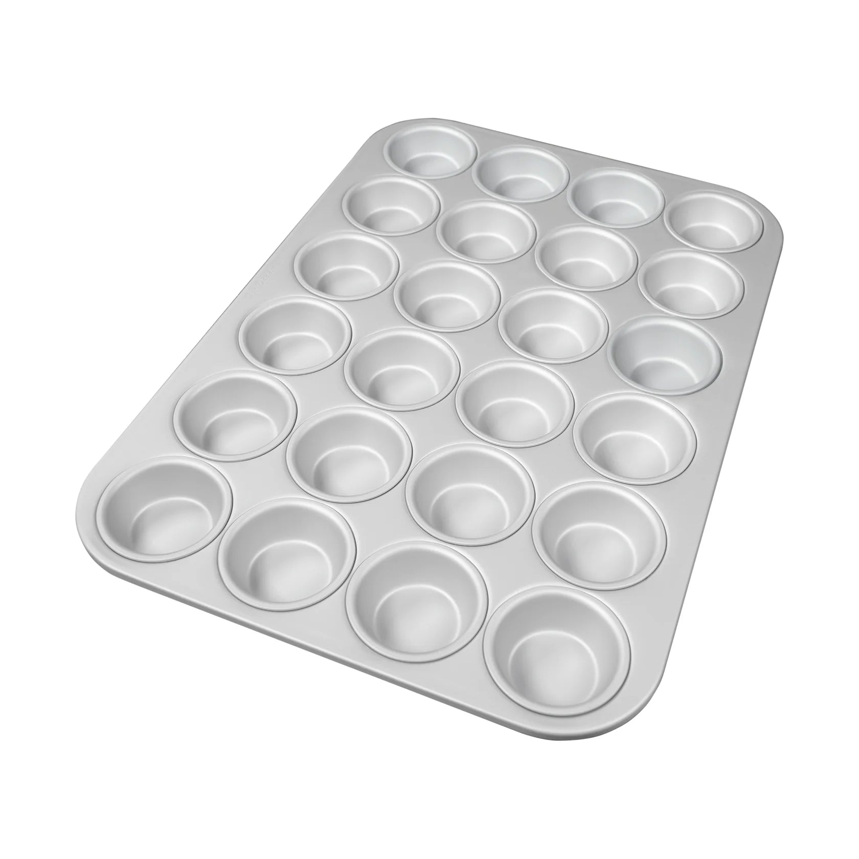 Silver mini muffin pan with 24 round cavities in a grid layout and a smooth rolled rim, shown at an angle on a white background.