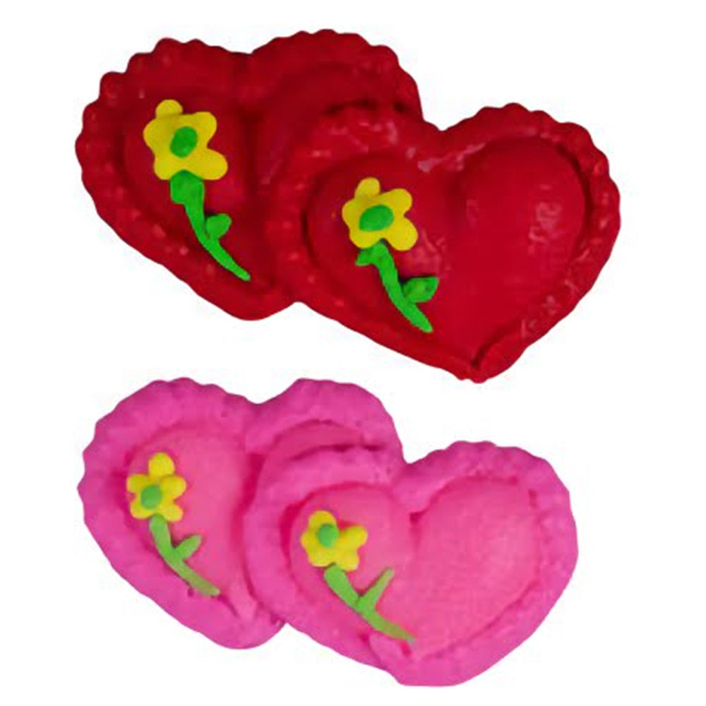 Two set of stacked pressed sugar heart decorations. One set pink one set red with a small yellow flower on each heart