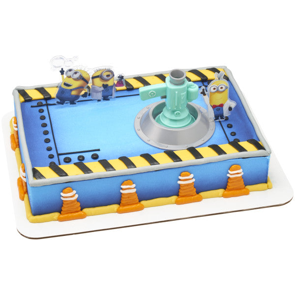 A rectangular cake decorated with blue and yellow details, construction cone decorations, and the Minions Fart Bubble Blaster DecoSet.