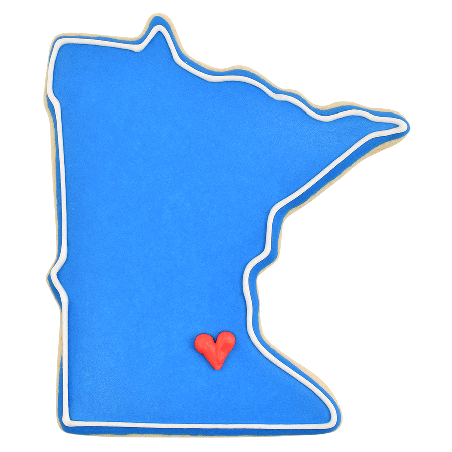 Blue Minnesota state-shaped cookie with a small red heart marking a location, made using the Minnesota state cookie cutter.