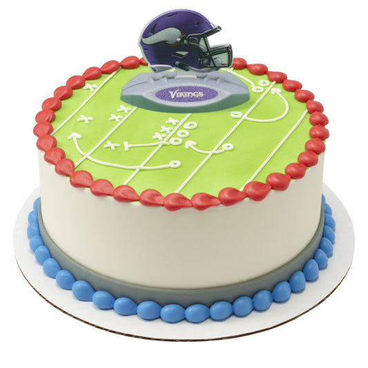 A round cake decorated as a football playfield with a Vikings helmet topper.