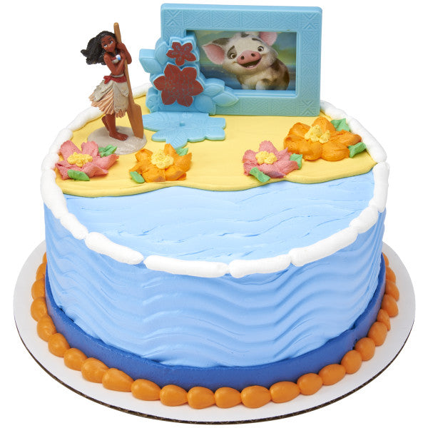 A round ocean-inspired cake decorated with island flowers and the Moana topper set.