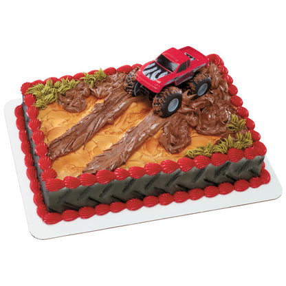 A rugged, off-road-themed cake with dirt-like frosting, tire tracks, and the Crusher monster truck topper.