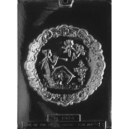 Clear plastic chocolate mold with one large round Mother’s Day plaque design featuring an ornate floral border and a detailed central scene.