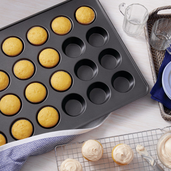 Wilton Perfect Results 24-cup non-stick muffin and cupcake pan, with cupcakes.