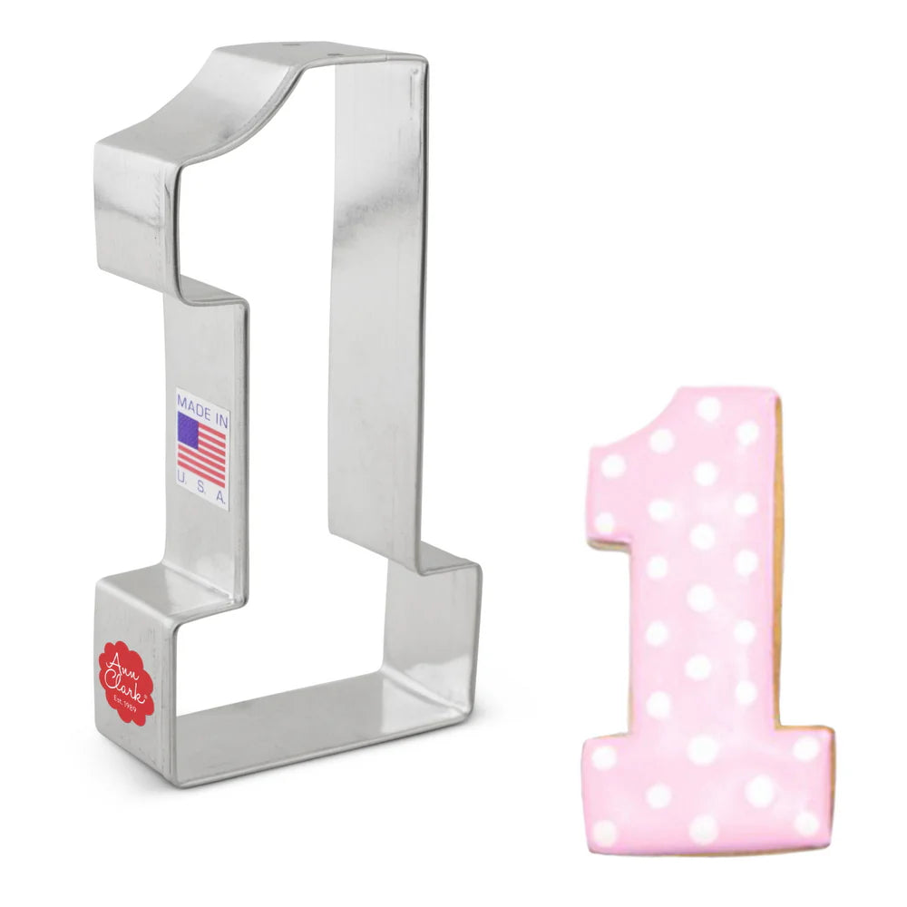 Number one cookie cutter with a decorated pink cookie featuring white polka dots.