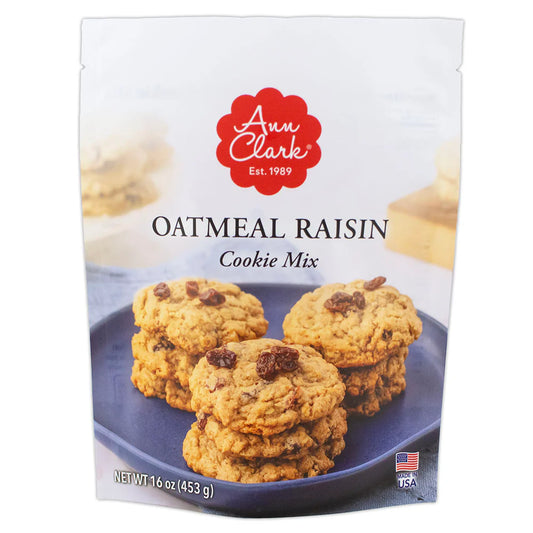 Front of Ann Clark Oatmeal Raisin Cookie Mix package featuring stacks of golden-brown cookies with visible oats and raisins on a blue plate.