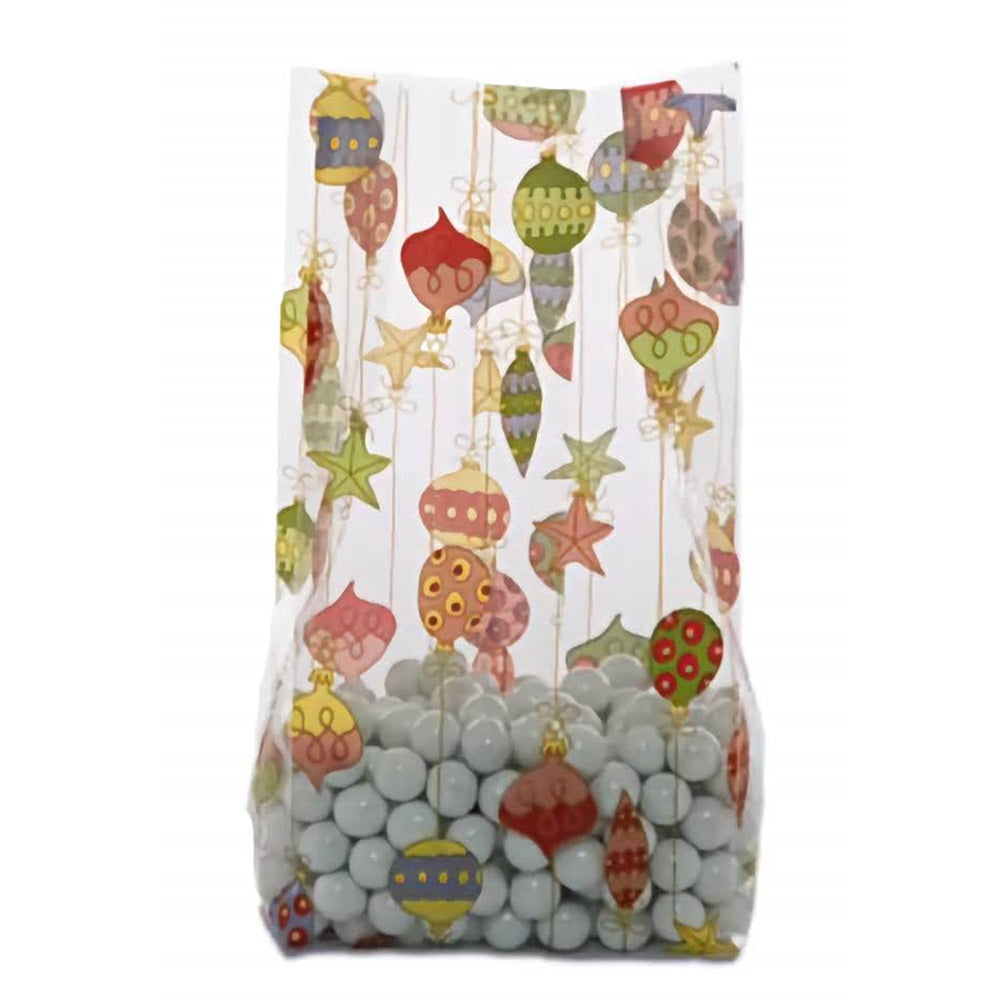 A medium-sized cellophane treat bag filled with pale blue round candies at the bottom. The bag is adorned with colorful Christmas ornaments hanging from fine golden strings, set against a transparent background. The variety of ornament designs and colors adds a festive and decorative look to the bag, ideal for holiday gifting and treats.