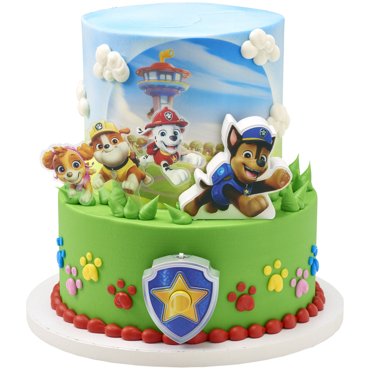 Two-tier PAW Patrol Adventure Bay Heroes cake with green and blue frosting, Chase launcher, shield badge, and character pic featuring Skye, Rubble, Marshall, and Chase.