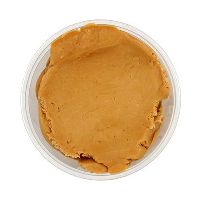 Top-down view of a container filled with peanut butter candy center, showing a smooth and spreadable texture.