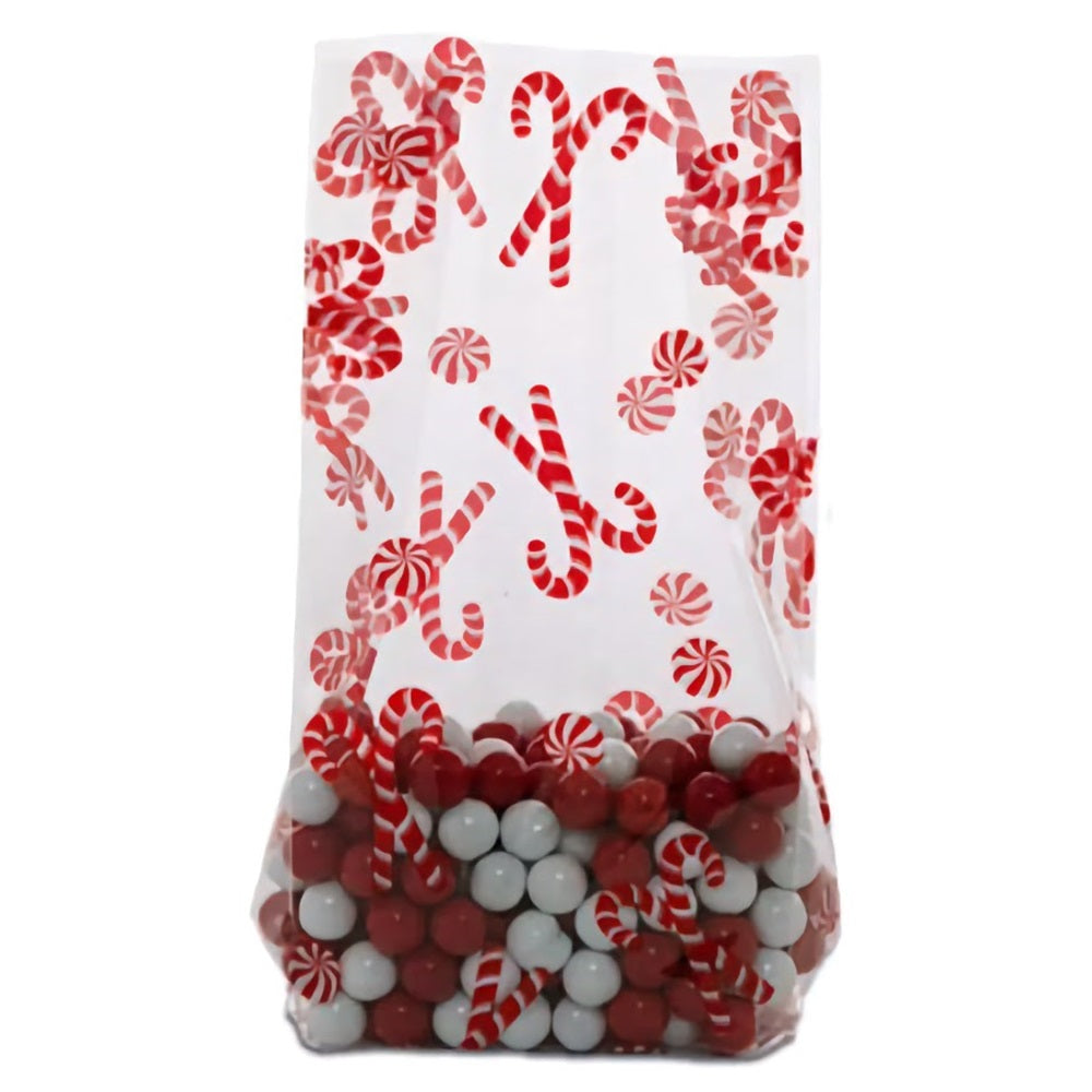 A small cellophane treat bag filled with a mix of red and white candies at the bottom. The bag is decorated with a pattern of red and white candy canes and peppermints, giving it a festive holiday appearance. The combination of the candy design on the bag and the actual candies visible through the transparent lower half makes for a cheerful and appetizing presentation.