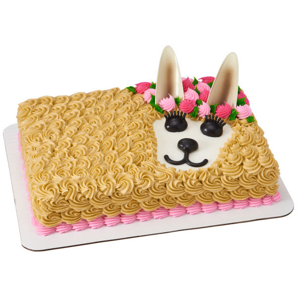 Rectangular cake decorated as a llama with piped fur, floral crown, and DecoSet facial features.