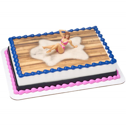 A whimsically decorated rectangular cake with a bikini woman topper, featuring a wooden deck icing design and blue border, available at Lynn's Cake, Candy, and Chocolate Supplies. It's a quirky addition to any summer pool party or a fun-filled adult celebration.