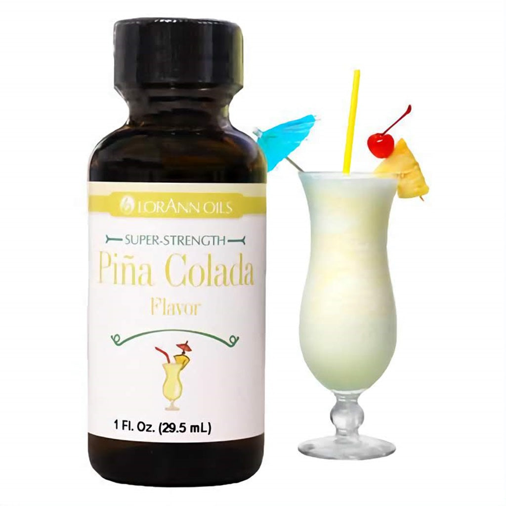 Brown glass bottle of LorAnn Oils Super-Strength Piña Colada Flavor with a decorative piña colada cocktail garnished with a cherry and pineapple slice in the background, highlighting the tropical essence for baking.