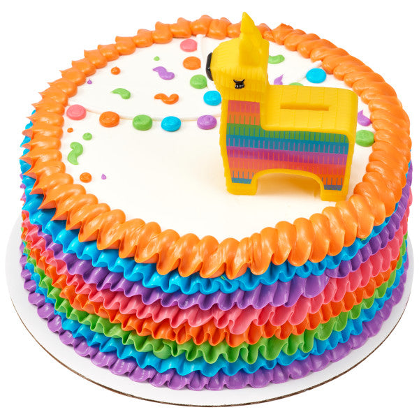 A vibrant cake with rainbow ruffles and confetti sprinkles, topped with the burro coin bank.