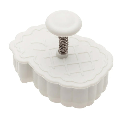 White pineapple plunger cutter with a round button and visible spring mechanism on top, shown on a white background.