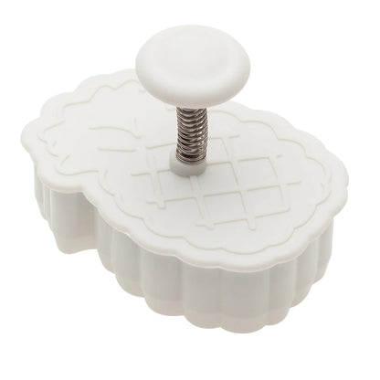 Side view of a white pineapple plunger cutter with a spring-loaded plunger and round handle for easy pressing.